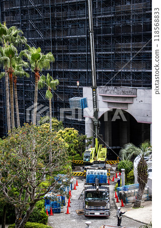 大型公寓大樓維修工地，起重機車將鷹架等臨時建築材料吊至高處。 118568833