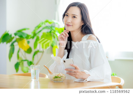 早餐時看智慧型手機的女人 118569562