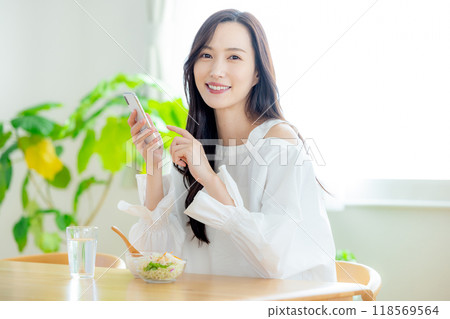 早餐時看智慧型手機的女人 118569564