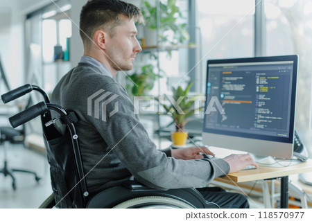 A man in wheelchair is focused on updating software at his desk, showcasing determination and skill 118570977