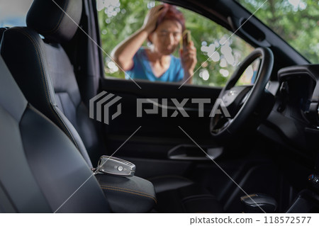 Senior asian woman forgot her key inside locked car. 118572577