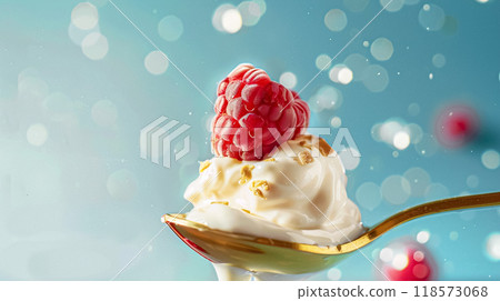 Golden spoon filled with creamy yoghurt and topped with fresh raspberries Golden spoon filled with creamy yoghurt and topped with fresh raspberries 118573068