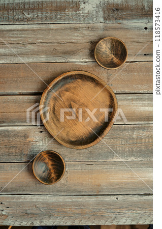 Natural wooden bowls arranged on a rustic wooden table highlighting artisanal craftsmanship Natural wooden bowls arranged on a rustic wooden table highlighting artisanal craftsmanship 118573416