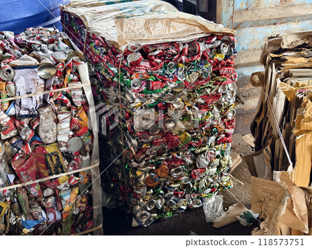 There is a large pile of crushed aluminum cans stacked on top of each other at the landfill. 118573751