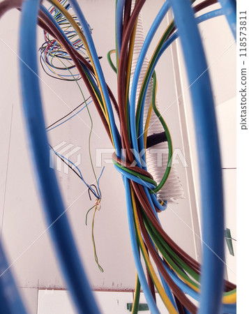 A collection of various wires is hanging down from the ceiling 118573811