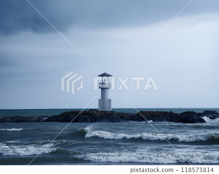 A solitary lighthouse stands in the ocean 118573814