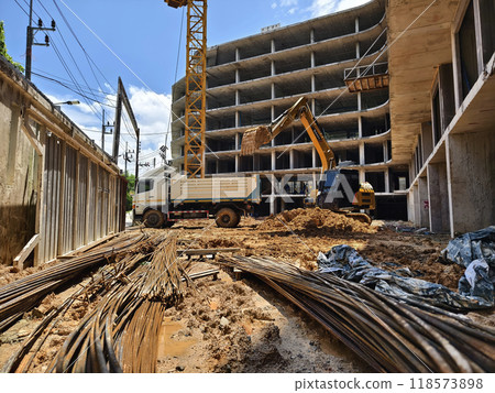 Excavator loads ground into a dump truck at a construction site Excavator loads ground into a dump truck at a construction site 118573898