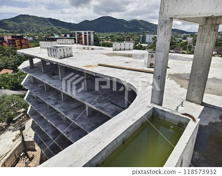 Large building with a roof pool of water under construction 118573932