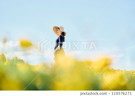 一個戴著帽子站在花田裡的女人 118576271