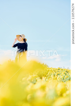 一個戴著帽子站在花田裡的女人 一個戴著帽子站在花田裡的女人 118576274