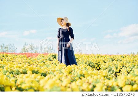 一個戴著帽子站在花田裡的女人 118576276