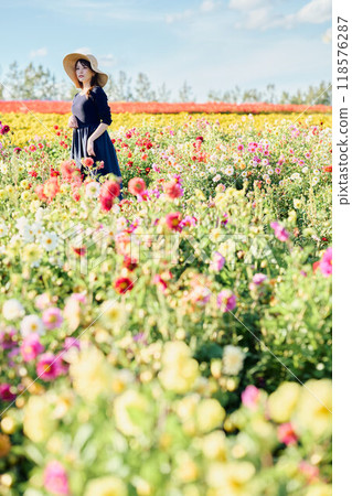 一個戴著帽子站在花田裡的女人 118576287