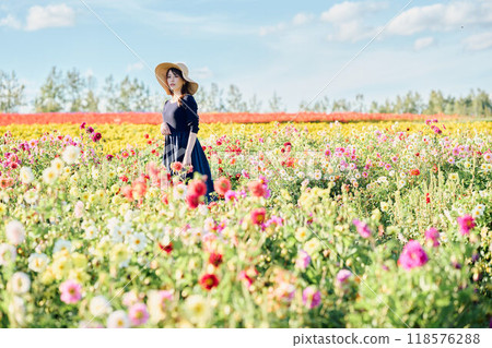 一個戴著帽子站在花田裡的女人 118576288