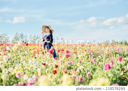 A woman wearing a hat standing in a flower field A woman wearing a hat standing in a flower field 118576289