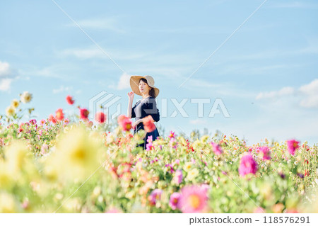 一個戴著帽子站在花田裡的女人 118576291