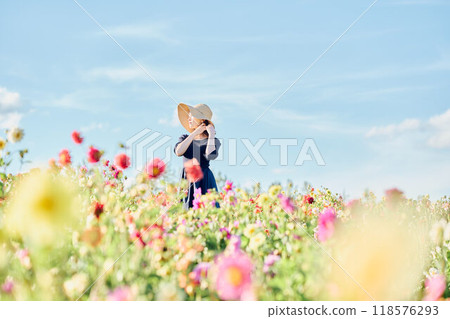 一個戴著帽子站在花田裡的女人 118576293