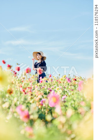 一個戴著帽子站在花田裡的女人 118576294