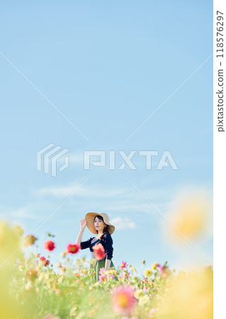 一個戴著帽子站在花田裡的女人 118576297