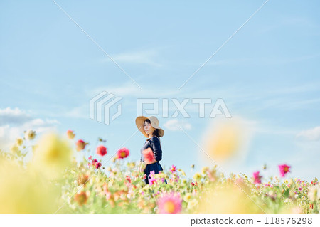A woman wearing a hat standing in a flower field A woman wearing a hat standing in a flower field 118576298