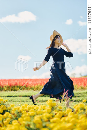 Woman running in a flower field 118576414