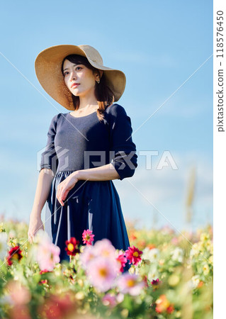 A woman wearing a hat standing in a flower field A woman wearing a hat standing in a flower field 118576450
