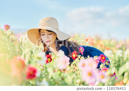 一個戴著帽子站在花田裡的女人 118576451