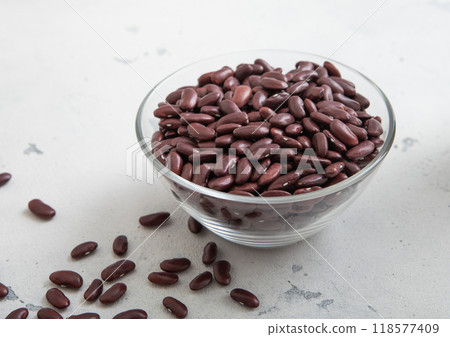 Dry raw organic purple beans in glass bowl on light table.Macro. 118577409