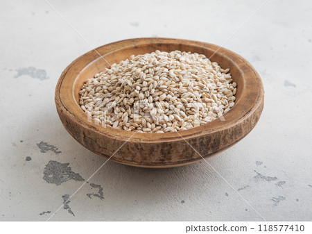 Wooden bowl of dry raw organic oats seeds on light table.Macro. 118577410