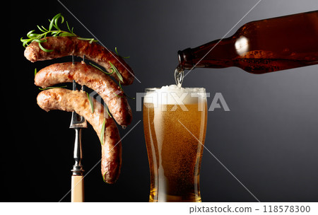 Beer and grilled Bavarian sausages with rosemary. Sausages on a fork sprinkled with rosemary. Beer and grilled Bavarian sausages with rosemary. Sausages on a fork sprinkled with rosemary. 118578300