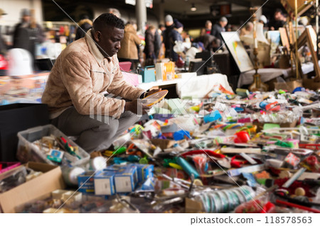 Man chooses antiques at a flea market Man chooses antiques at a flea market 118578563