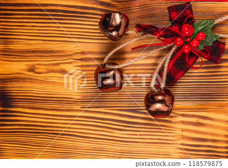 Christmas decoration bow and bells on a wooden background 118579875