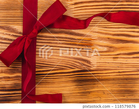Dark red ribbon and bow on a beautiful wooden background Christmas concept Dark red ribbon and bow on a beautiful wooden background Christmas concept 118579876
