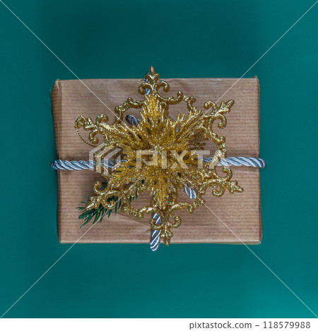 Christmas gift box with gold flower on green background Christmas gift box with gold flower on green background 118579988