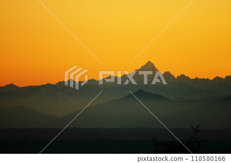 A sunset over a body of water with a mountain in the background 118580166