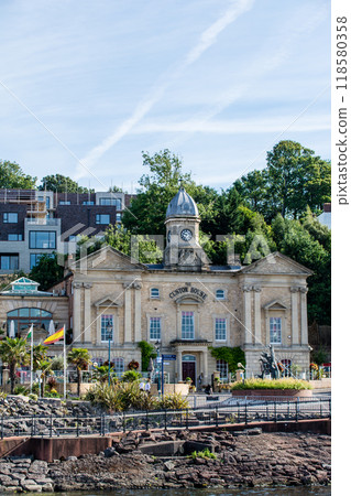 Historic brick building with clock tower built at the bottom of a hill in rural South Wales 118580358