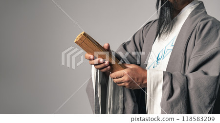 A scene of a Chinese historical figure, such as Zhuge Liang from the Romance of the Three Kingdoms, presenting a bamboo slip. 118583209