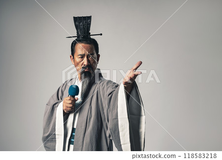 A scene in which a historical figure from China, such as Zhuge Liang from the Romance of the Three Kingdoms, gives a speech at a microphone 118583218
