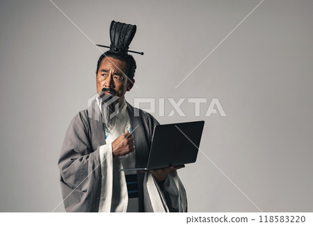 A scene where a Chinese historical figure, such as Zhuge Liang from Romance of the Three Kingdoms, uses a laptop 118583220