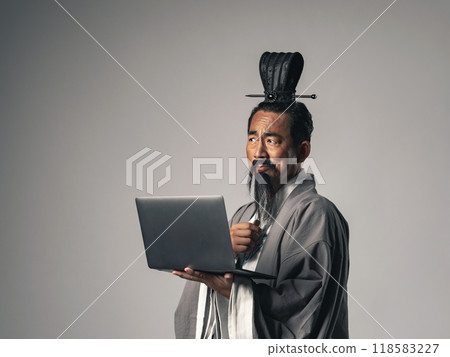 A scene where a Chinese historical figure, such as Zhuge Liang from Romance of the Three Kingdoms, uses a laptop 118583227