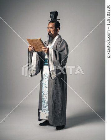 A scene in which a Chinese historical figure, such as Zhuge Liang from the Romance of the Three Kingdoms, reads characters written on bamboo slips. 118583230