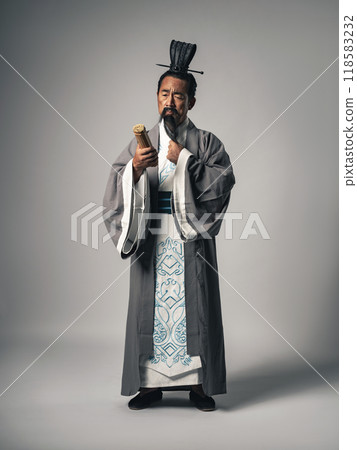 A scene of a Chinese historical figure, such as Zhuge Liang from the Romance of the Three Kingdoms, pondering while holding a bamboo slip document 118583232