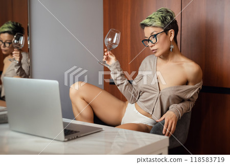 A beautiful girl with short hair in her underwear is sitting sexy in a room at a laptop, working and chatting online A beautiful girl with short hair in her underwear is sitting sexy in a room at a laptop, working and chatting online 118583719