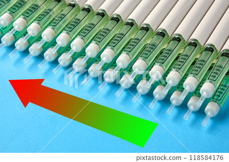 Rows of insulin syringes pens and an upward arrow on a blue background. The rise of diabetes cases Rows of insulin syringes pens and an upward arrow on a blue background. The rise of diabetes cases 118584176