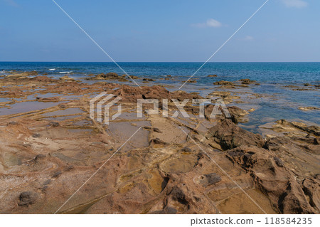 Rocky Coastal Terrain with Shallow Tide Pools on a Clear Day Rocky Coastal Terrain with Shallow Tide Pools on a Clear Day 118584235
