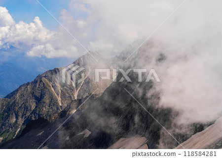 Misty Mountain Peaks Under a Cloudy Sky 118584281