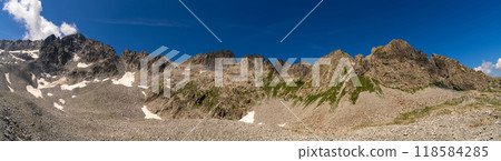 xRugged Mountain Peaks with Rocky Terrain Under Clear Blue Sky 118584285