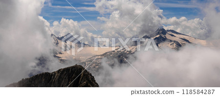 Majestic Mountain Peaks Emerging Through Clouds 118584287
