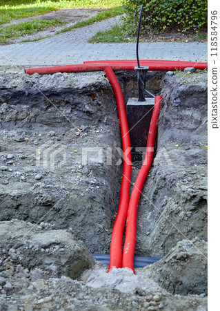 Communication underground red pipes hoses on construction road repair site Communication underground red pipes hoses on construction road repair site 118584796