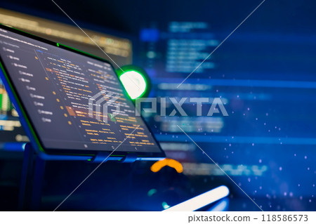 Programmer manually working with program code on a computer at night in a data center and technology concept. 118586573