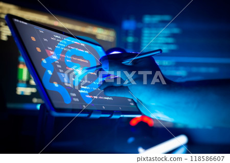 Programmer manually working with program code on a computer at night in a data center and technology concept. 118586607
